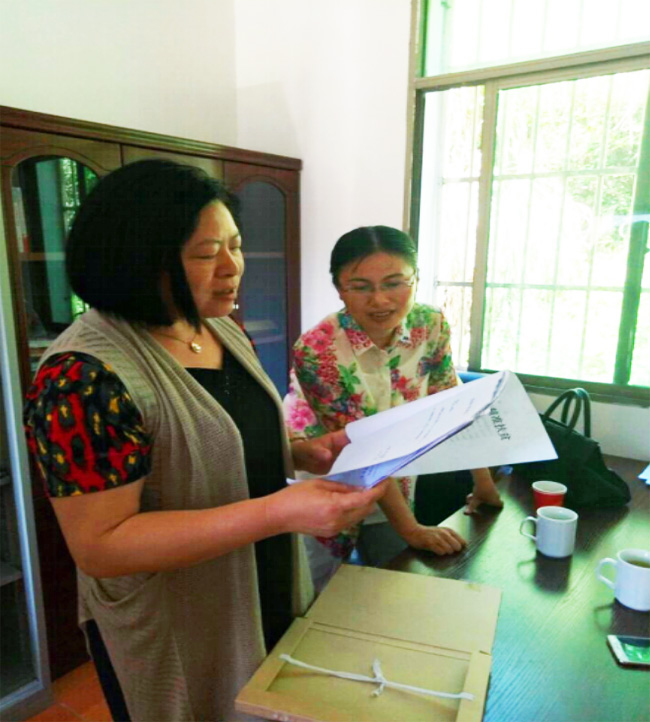 卢小梅仔细翻阅“一户一档”内容 卢小梅仔细翻阅“一户一档”内容